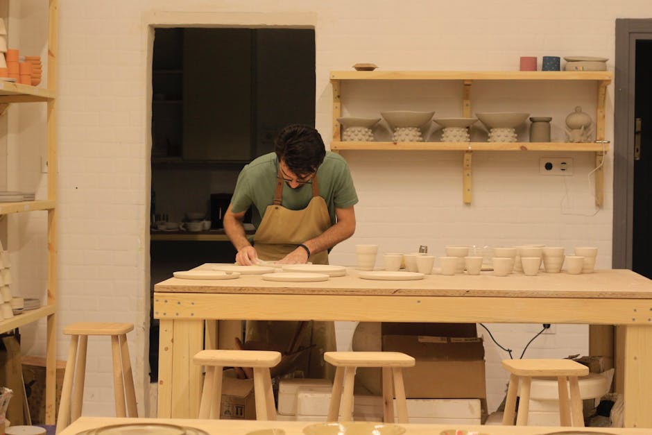 A potter working meticulously in a cozy workshop, creating unique ceramic pieces.